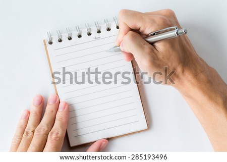 Close-up of man hand writes in a notebook