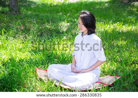 Girl meditation in the park. Peace position of girl meditate on grass in park. Meditation affects the control of body and mind. Helps the body relax from work or fatigue as well.