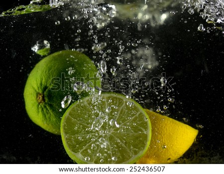 lemon and lime in water drop (on the black background)