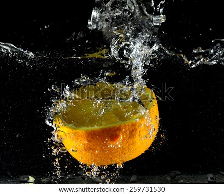 Orange falling into the water, the clash of the fruit with water