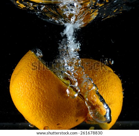 Orange falling into the water, the clash of the fruit with water