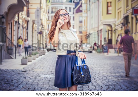 girl talking on the phone. Girl with a bag. against the backdrop of the city