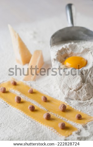 Dough ingredients, flour, eggs, parmigiano cheese. slices of dough whit meat ball