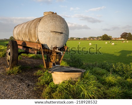 Water tanker by dutch meadow during sunset