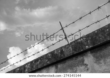 The home walls with high walls and barbed iron wire, black and white version