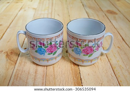 Teacup with floral rose ornament in classic style on wooden board