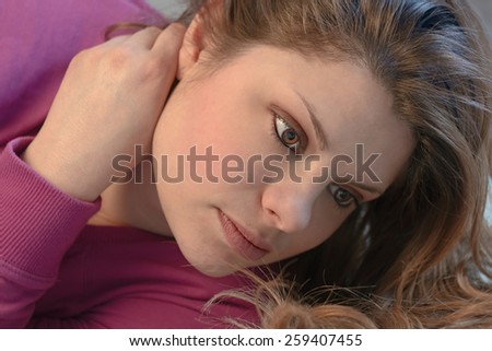 Beautiful girl with a thoughtful look and hands behind the neck