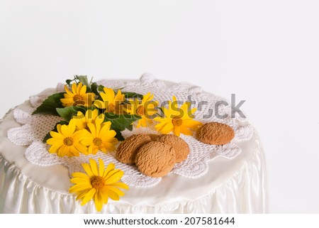 fragrant yellow oat cakes with fresh flowers on the table, on a white background