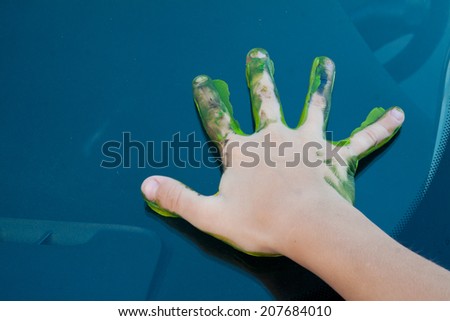 colorful children\'s palm print in the paint on the hood of the car