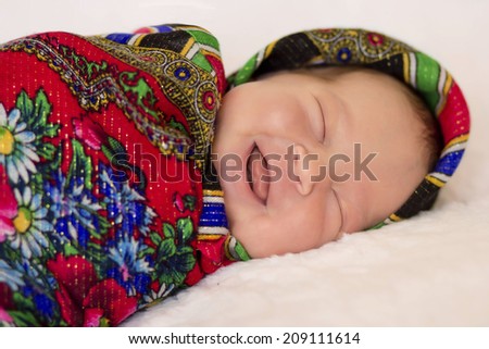 beautiful sleeping newborn baby in knitted cap under the rug, five days old