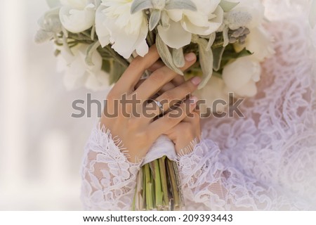 hands up on the bride with a ring and a wedding bouquet