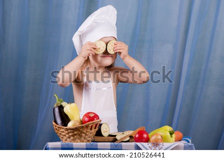 Little cook prepares healthy food, cheery kitchen boy at the table