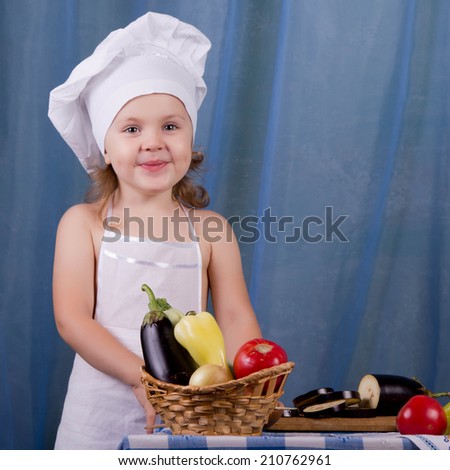 Little cook prepares healthy food, cheery kitchen boy at the table