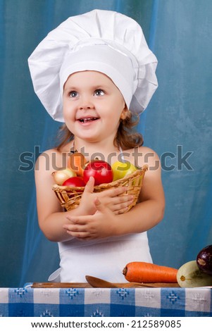 Little cook prepares healthy food, cheery kitchen boy at the table, cheery kitchen boy holding a basket of vegetables