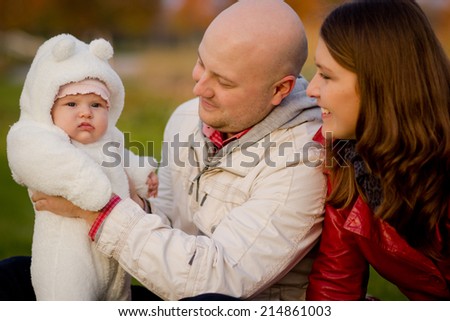 Happy family on a walk in the park. Dad, mom and baby are happy autumn weather and communication