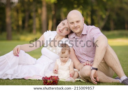 Happy family relaxing on the lawn in the summer, park, walk, rest, picnic