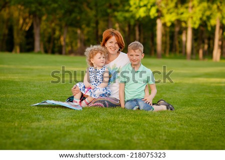 Family picnic in the park, happy mother with children