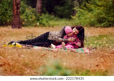 Mother and daughter in the autumn picnic in the woods