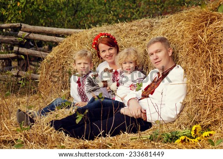 Ukrainian family in the village on a background of hay.
