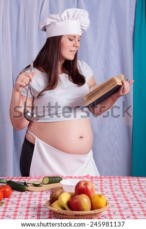 Pregnant woman cook with fruits and vegetables in the kitchen. The concept of proper nutrition while waiting for baby