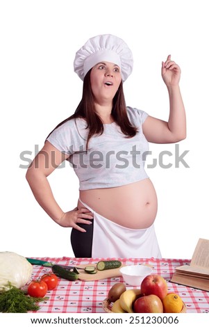 Surprised pregnant woman cook with fruits and vegetables in the kitchen. Shows the \