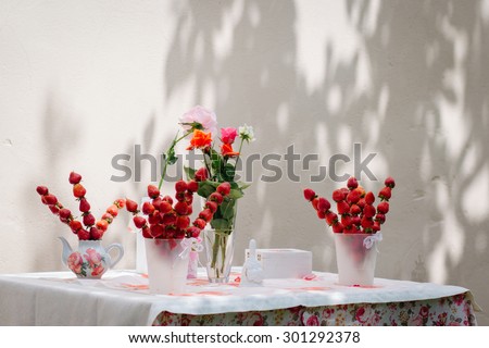 Table decoration, children\'s holiday, wedding, decoration, buffet. Strawberry skewers, roses on the table