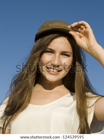 Teenage girl tips her hat