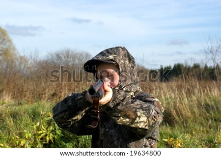 The girl in a camouflage aiming from a gun
