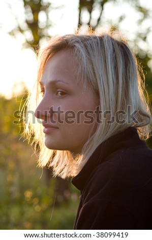 Portrait of the young blonde  girl shined with the sunset sun.