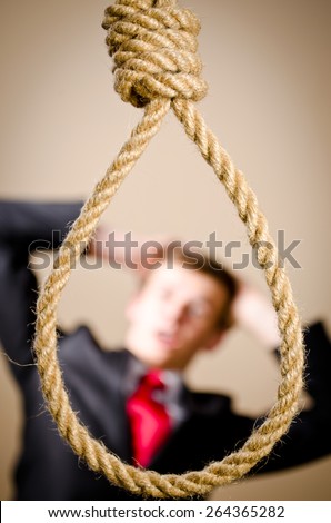 Scared man in suit with hanging noose