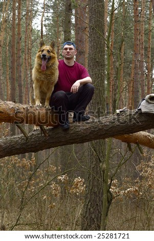 Portrait of man with a dog in the forest on the thrown-down trees