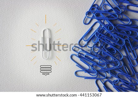 Individuality symbol and independent thinker concept and new leadership concept or individuality as a group of paperclip on canvas with one individual in the opposite direction as a business icon.