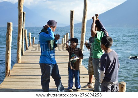 San Marcos, Solola Department, Guatemala - January 29, 2015: Local Maya people stand on the little dock at the Lake Atitlan on January 29, 2015 in San Marcos, Guatemala