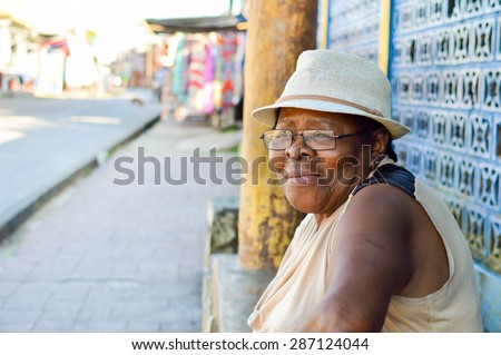 Livingston, Guatemala - March 8, 2015: Garifuna woman looks aside with a sad smile on March 8, 2015 in Livingston, Guatemala. Garifuna are the group of indigenous people along Caribbean coast