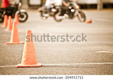 Motorcycle training school. Short depth of field. Focus on cone in foreground.