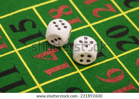 roll of the white dice on  game table in a casino