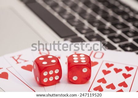Casino chips, cards and dices stacking on laptop
