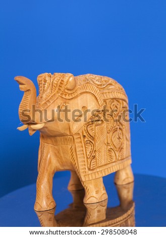Wooden elephant sculpture on blue background