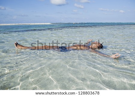 Man floating in water on the beach