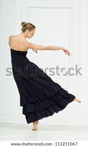 Girl in a black dress moves nicely in dance