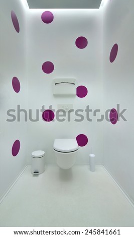 Public toilet in a modern loft style. Minimalism, toilet, brush, trash. The walls are painted in purple spots.