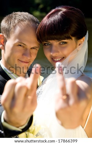 happy couple is showing wedding rings with a smile