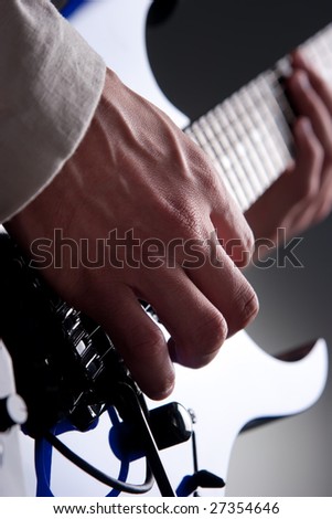 Detail of mans hands playing electric guitar