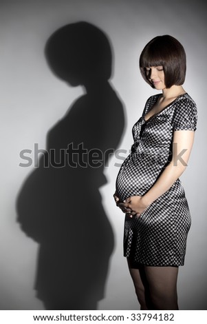 silhouette of woman eight months pregnant.