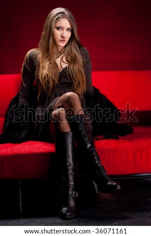 Attractive young woman lounging on the couch in studio.