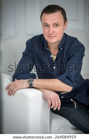 Man sitting in the sofa with a slight smile