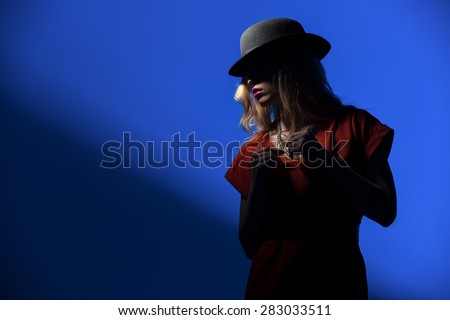 Contrast portrait of sexy blonde in a red hat