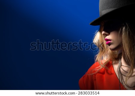 Contrast portrait of sexy blonde in a red hat