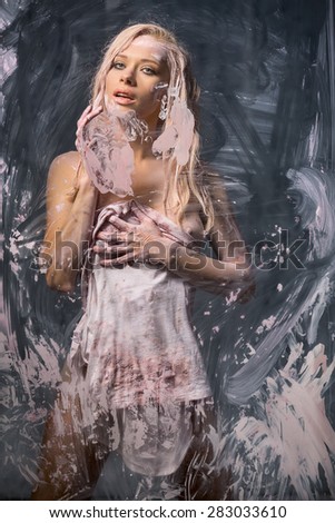 Portrait of seminude blonde through the glass smeared pink clay