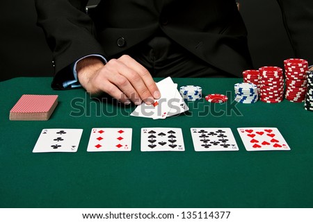 Young lucky gambler with cards and chips.